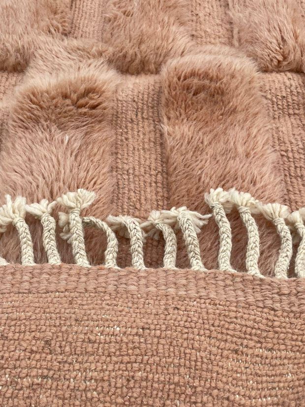 Lisière et franges d'un tapis terracotta
