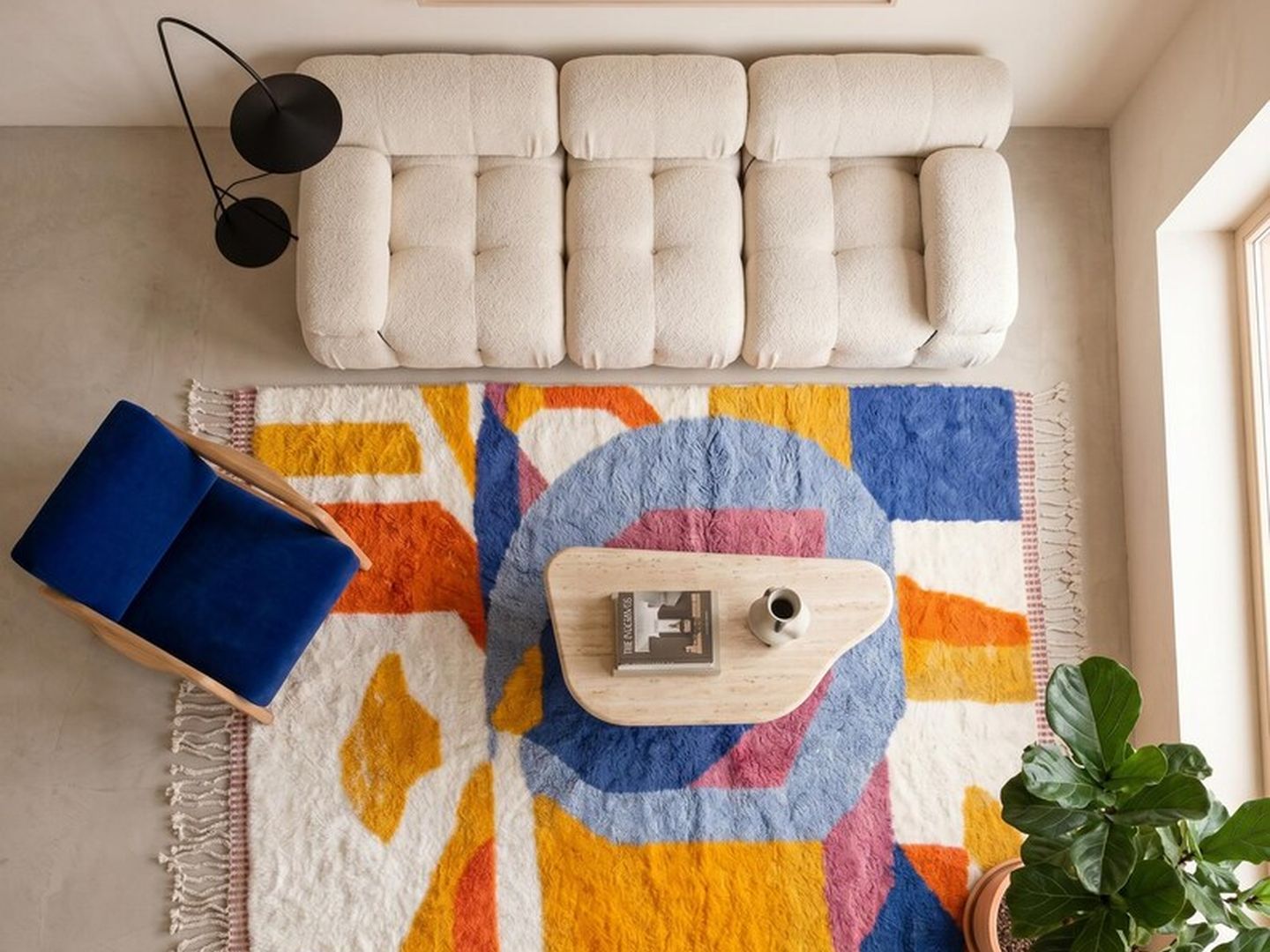 Vue de dessus d'un tapis à composition abstraite colorée devant un canapé bouclé